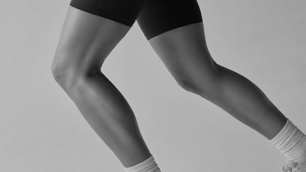 A runner mid-stride, legs in black and white