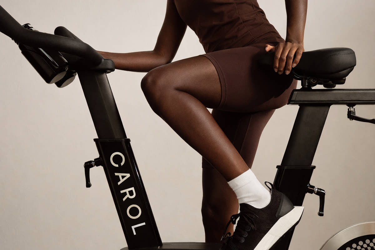 A rider stepping onto a CAROL bike, seen from the side