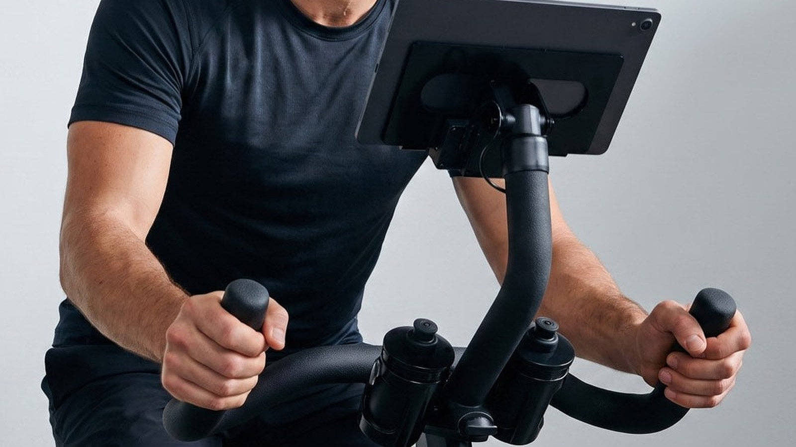 A rider's torso, arm and hand on the CAROL Bike handlebars